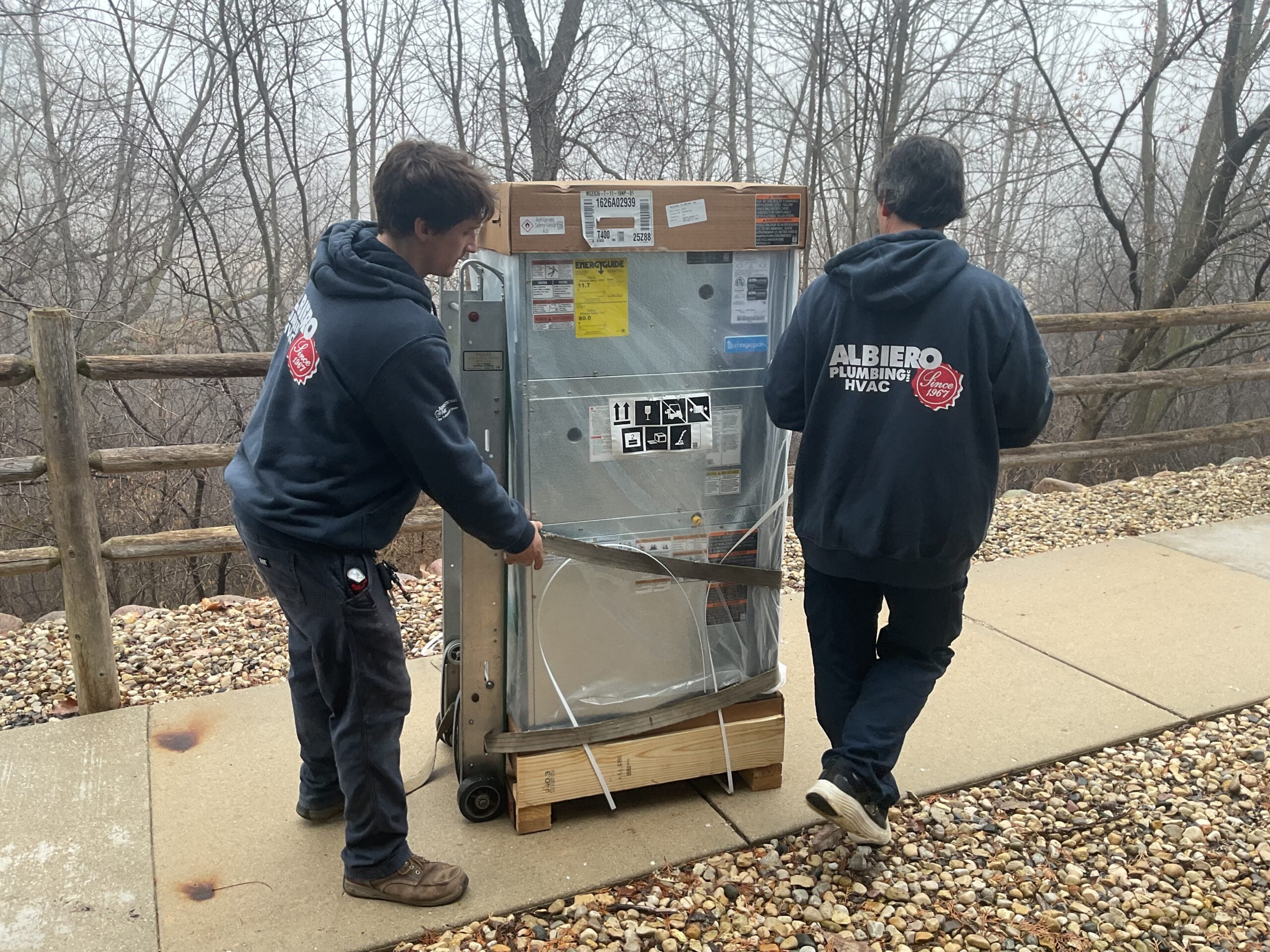Two Albiero techs moving new furnace unit to home