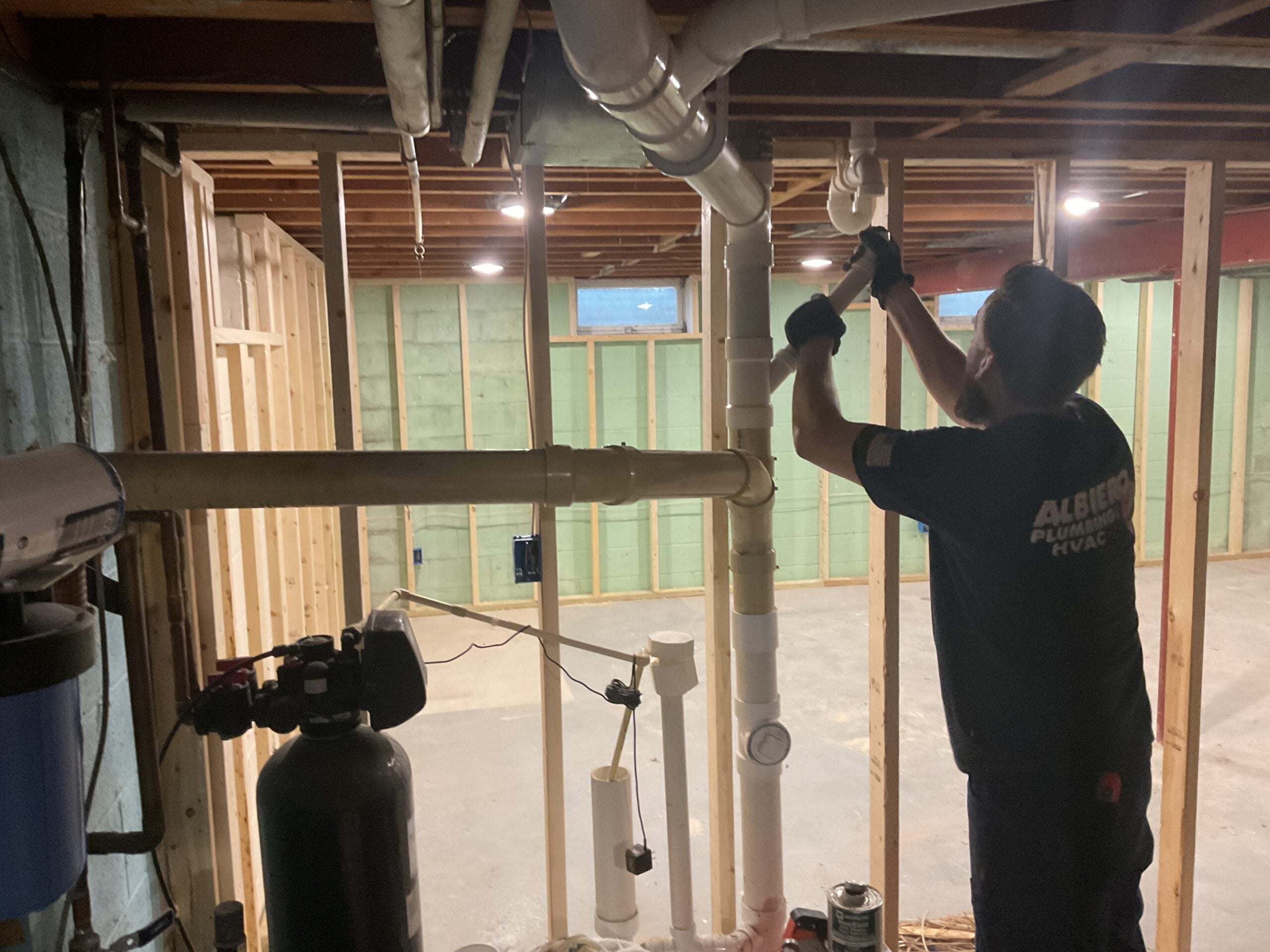 Albiero tech working on pipes in basement