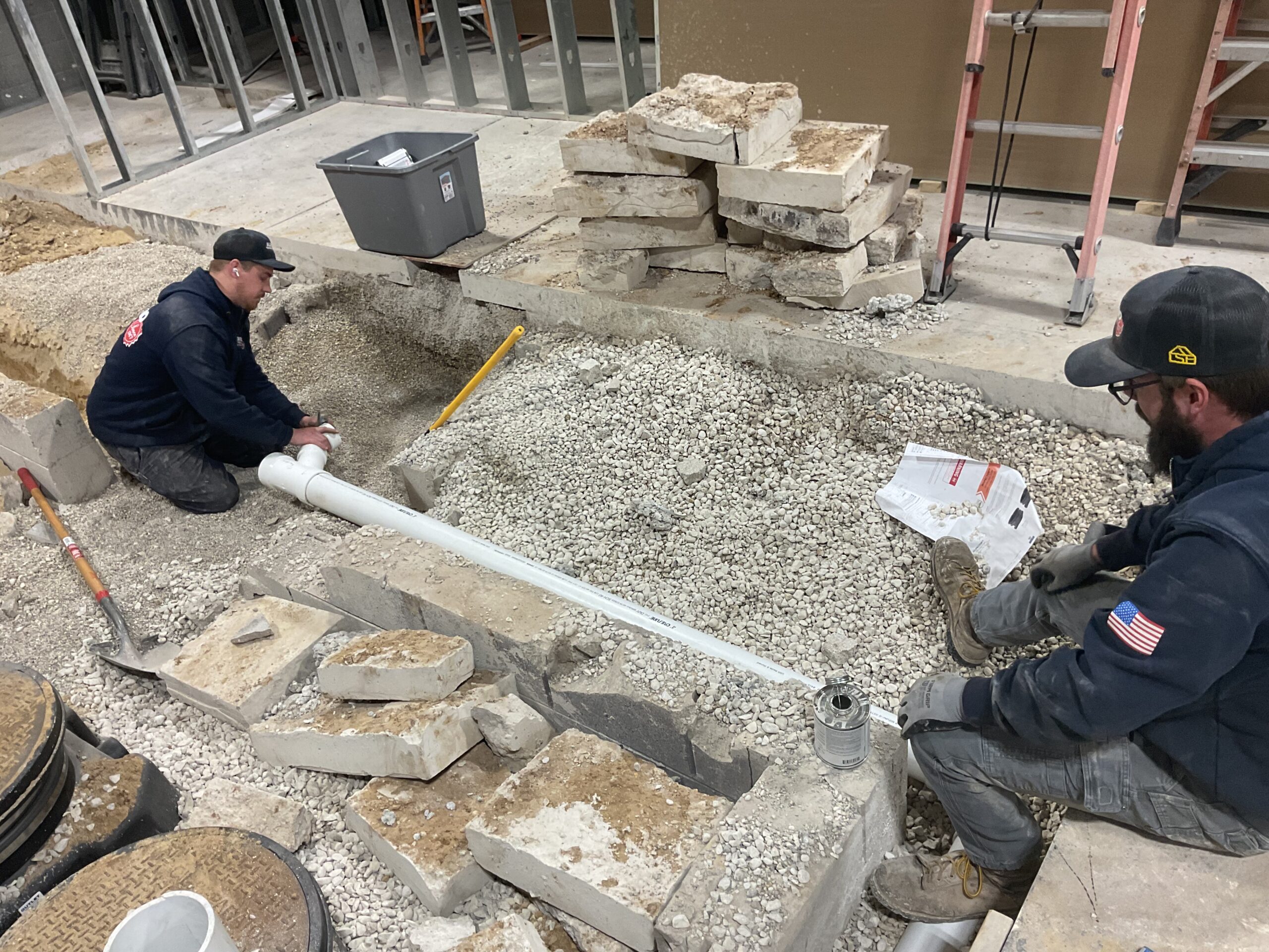 Two Albiero techs working on outdoor sewer pipe