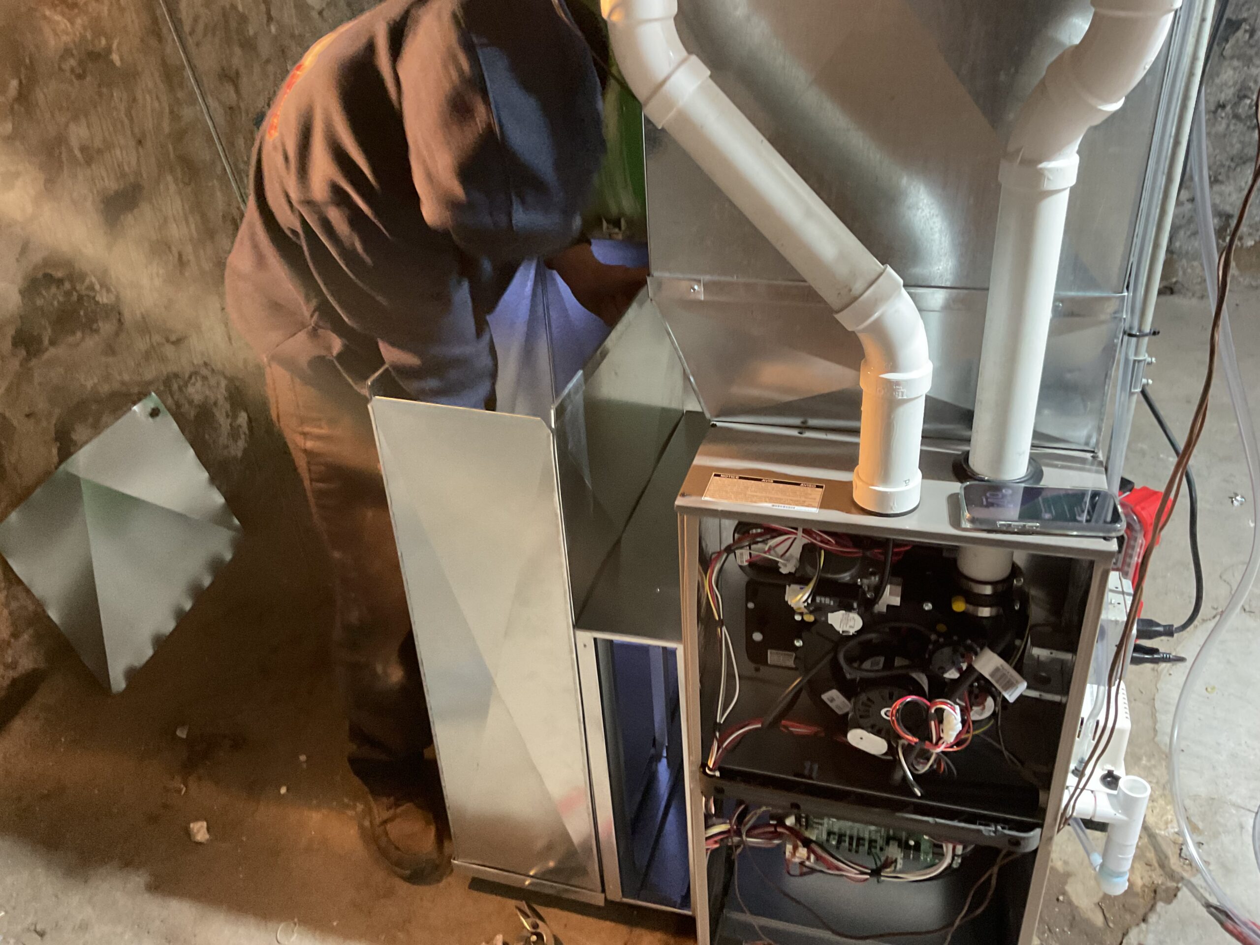 Albiero tech working behind furnace in basement