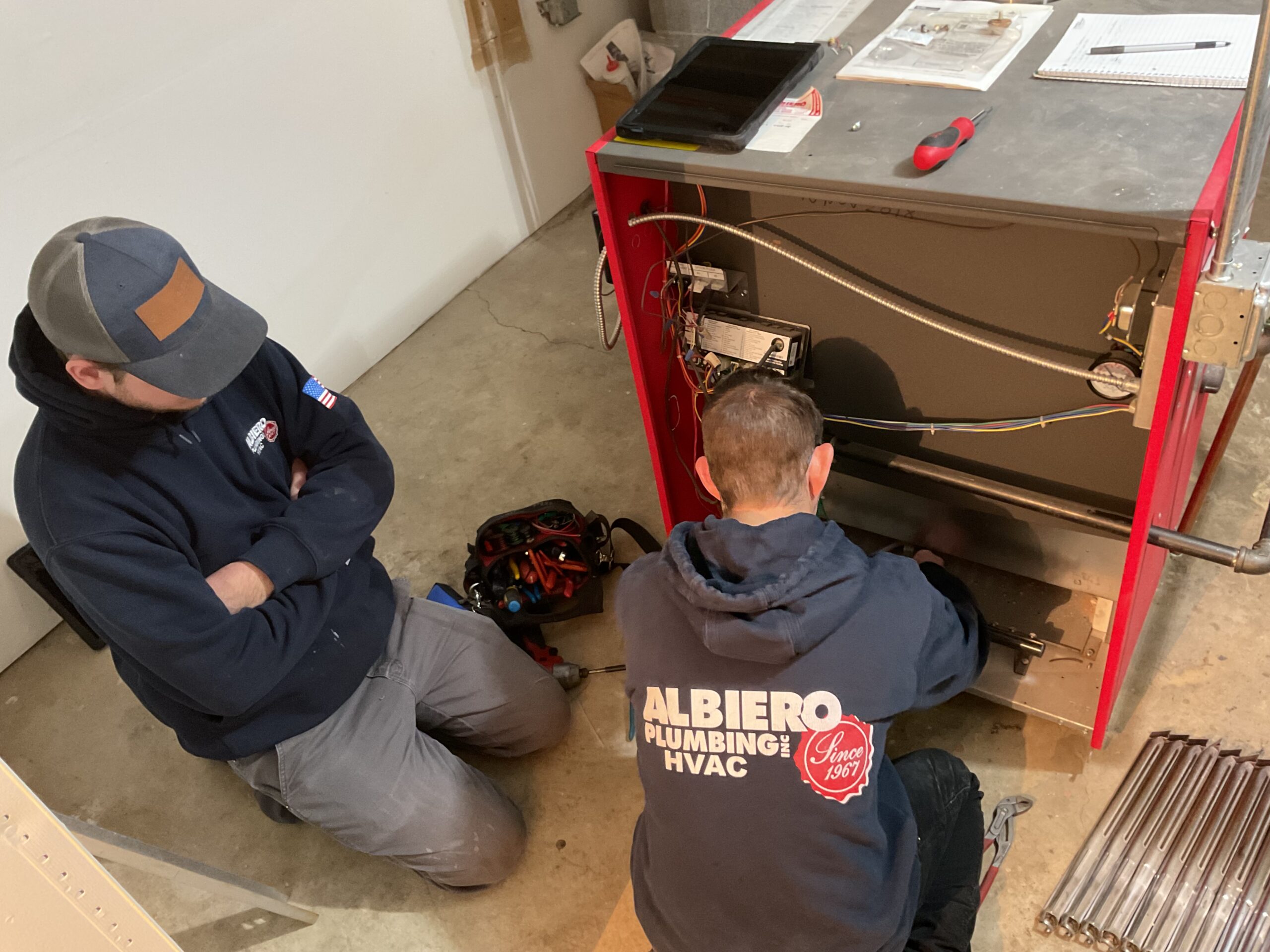 Two Albiero techs servicing red furnace unit
