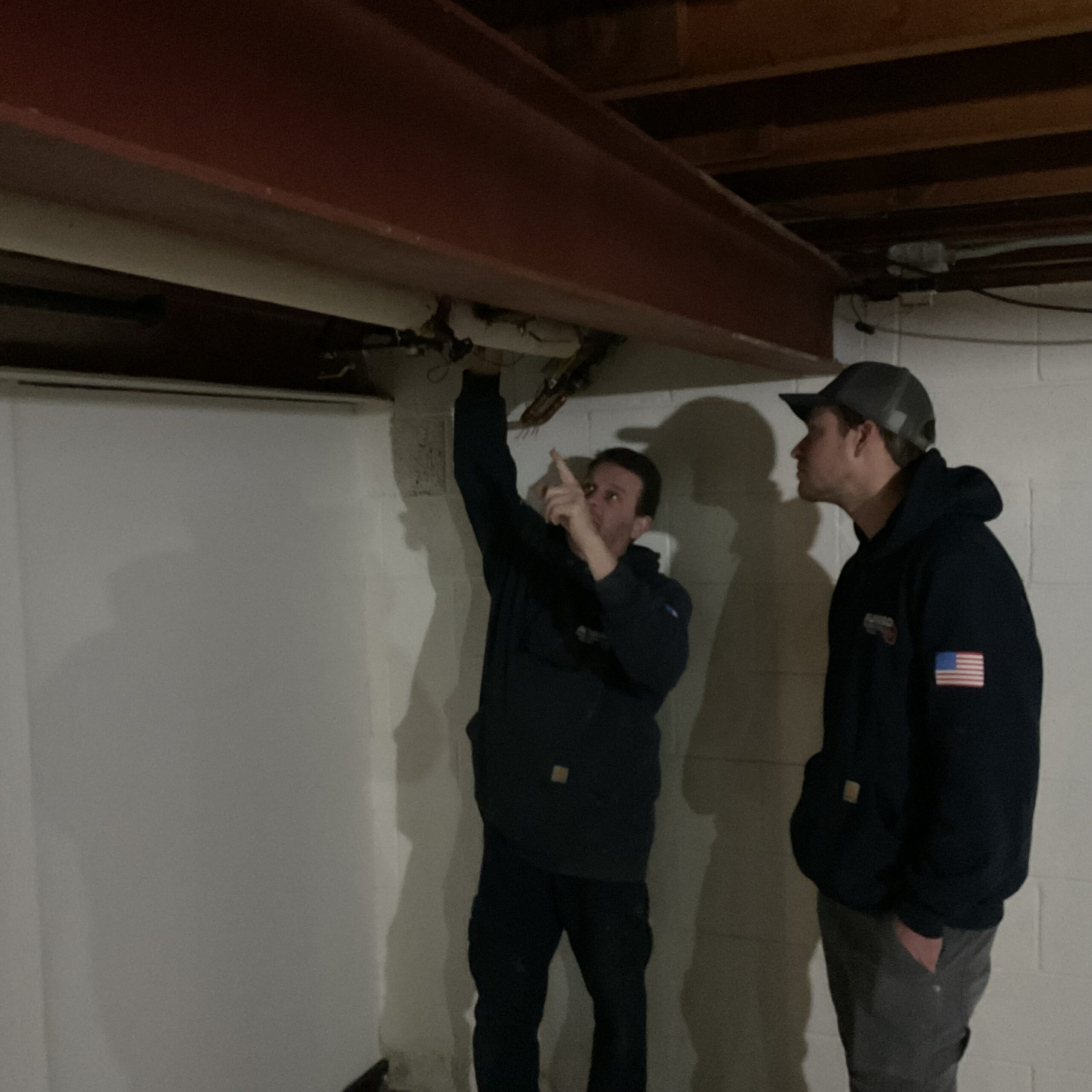 Two Albiero techs inspecting basement HVAC infrastructure